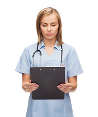 Image showing smiling female doctor or nurse with clipboard