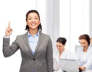 Image showing smiling businesswoman with her finger up at office