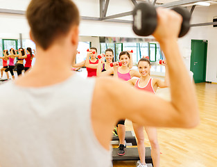 Image showing group of smiling female with dumbbells and step