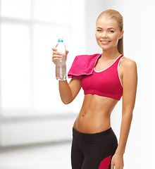 Image showing smiling woman with bottle of water and towel