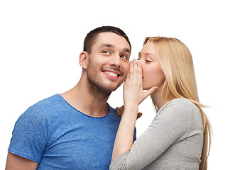 Image showing smiling girlfriend telling boyfriend secret