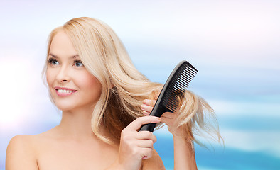 Image showing smiling woman with hair brush