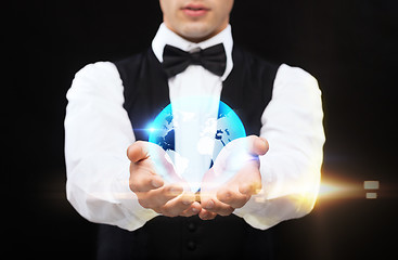 Image showing dealer holding globe on palms of his hands