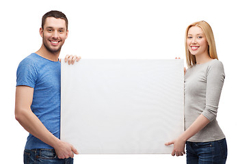 Image showing smiling couple holding white blank board