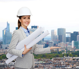 Image showing smiling architect in white helmet with blueprints