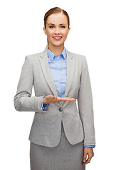 Image showing smiling businesswoman holding something imaginary