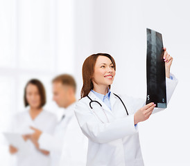 Image showing smiling female doctor looking at x-ray