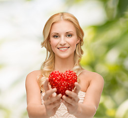 Image showing smiling woman giving small red heart