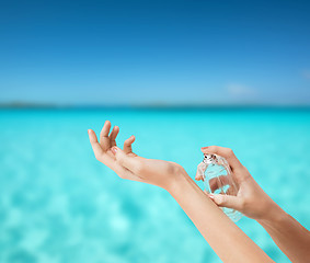 Image showing woman hands spraying perfume