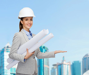 Image showing smiling architect in white helmet with blueprints