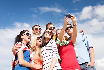 Image showing group of friends taking picture with smartphone