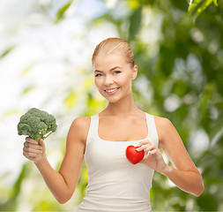 Image showing smiling woman holding heart symbol and broccoli