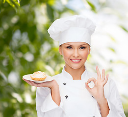 Image showing smiling female chef with cake on plate