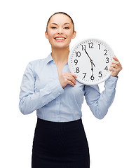 Image showing attractive businesswoman with wall clock