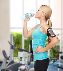 Image showing sporty woman running with smartphone and earphones