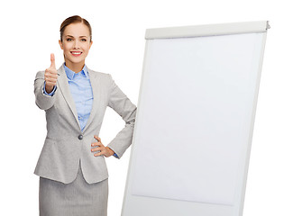 Image showing smiling businesswoman standing next to flip board