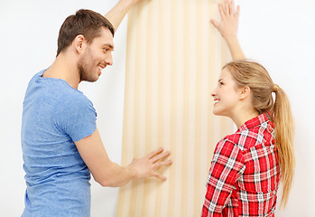 Image showing smiling couple choosing wallpaper for new home