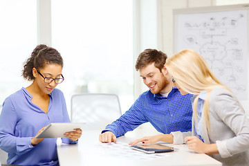 Image showing smiling team with table pc and papers working