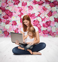 Image showing happy mother with adorable little girl and laptop