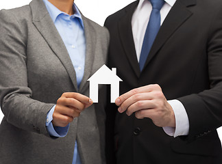 Image showing businessman and businesswoman holding white house