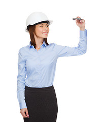 Image showing businesswoman in helmet writing on virtual screen