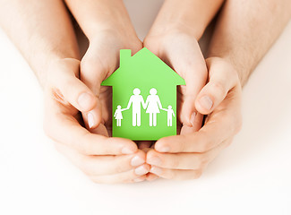 Image showing hands holding green house with family