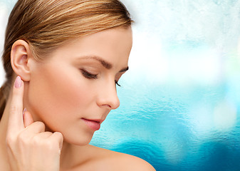 Image showing calm woman touching her ear