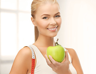 Image showing sporty woman with apple and measuring tape