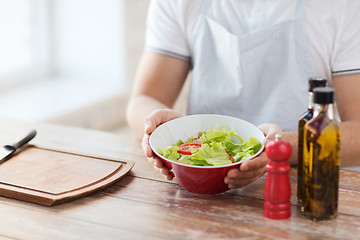 Image showing close of male hand holding a bowl with salad