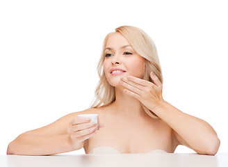 Image showing beautiful woman applying cream on her skin