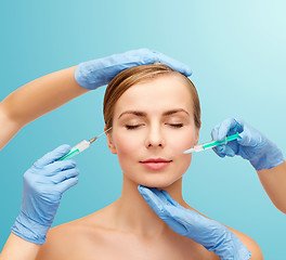 Image showing woman face and beautician hands with syringe