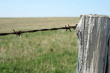 Image showing Old wooden post and barbed wire