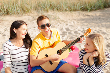 Image showing group of friends with guitar having fun on beach