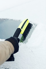 Image showing man cleaning snow from car windshield with brush