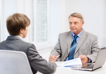 Image showing older man and young man having meeting in office