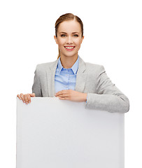 Image showing smiling businesswoman with white blank board