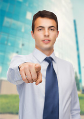 Image showing friendly young buisnessman pointing finger