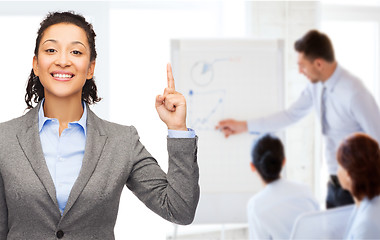 Image showing smiling businesswoman with her finger up at office