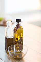 Image showing close up of two olive oil bottles and bowl of oil