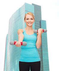 Image showing young sporty woman with light dumbbells