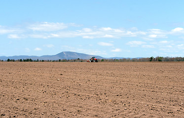 Image showing Tractor plowing land in spring