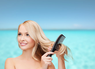 Image showing smiling woman with hair brush