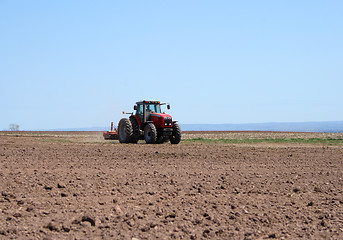 Image showing Tractor plowing land