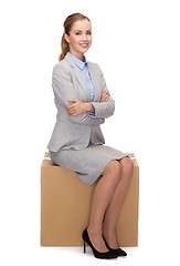 Image showing smiling woman sitting on cardboard box