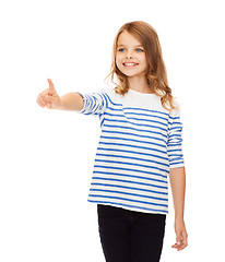 Image showing cute girl pointing in the air or virtual screen