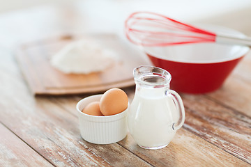 Image showing jugful of milk, eggs in a bowl and flour