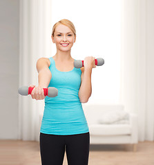 Image showing young sporty woman with light dumbbells