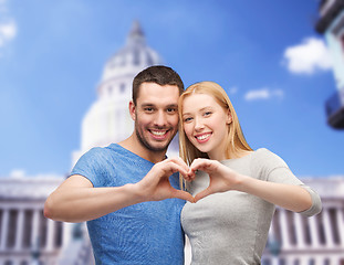 Image showing smiling couple showing heart with hands