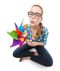 Image showing woman in eyeglasses sitting on floor with windmill