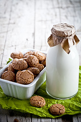 Image showing meringue almond cookies in a bowl and bottle of milk 